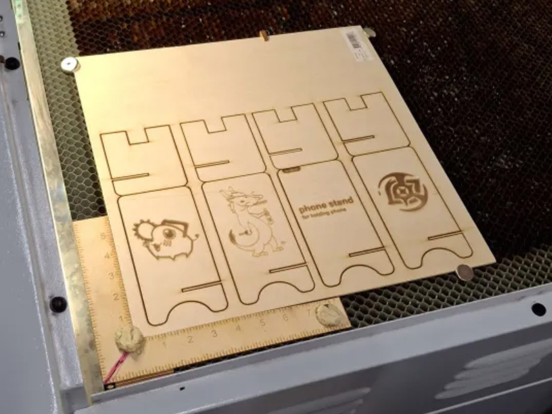 After the design, the laser went through the template lines and cut out the phone holders through the wood. The wood that my group used for this was actually a bit thicker, so it had to go throught a second round to cut through completely.